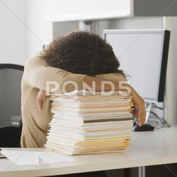 African Businesswoman Leaning On Stack Of Paperwork