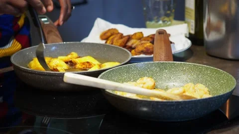 African chef frying plantain tree fruit with extra virgin olive oil on induct Vídeo Stock 220075488