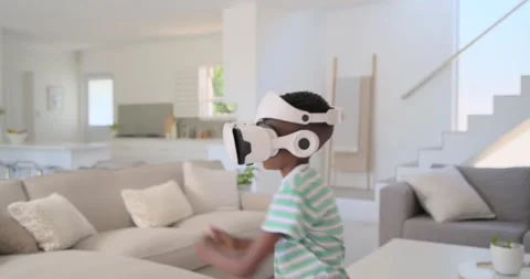 African child putting on white VR headset, wearing striped tee, moving, Stock Footage 337160576