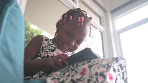African child sitting resting on sofa in living room using digital tablet watch Stock Footage 136678383