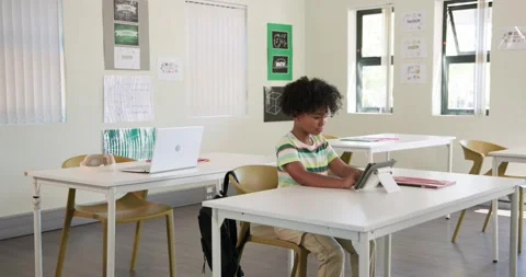 African child student tapping tablet adjusting stand and studying in class while Stock Footage 336247493
