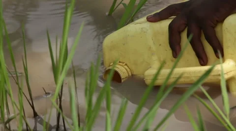 African child using a large bottle to fill water Stock Footage 54998778