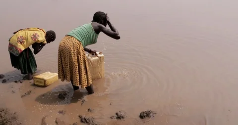 African Children fetching dirty drinking water using bottles to fill sour water Stock Footage 116361002
