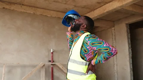 African construction worker clutches aching lower back on job site Video stock 346258314