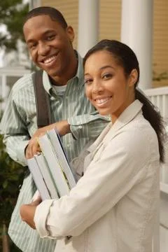 African couple carrying books and backpack Stock Photos