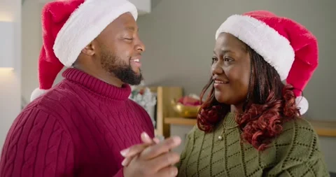 African couple dancing after man singing, twirling, smiling by Xmas tree in Stock Footage 342067965