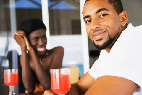 African couple drinking cocktails on patio Stock Photos