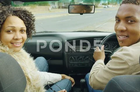 African couple driving in convertible car Stock Photos