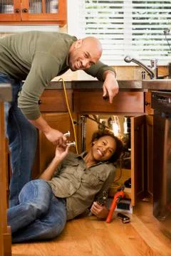 African couple installing kitchen sink Stock Photos