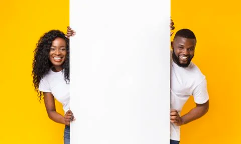 African couple posing with white empty board Stock Photos