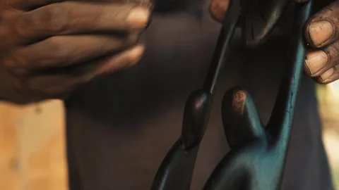 "African Craftsmanship: Close-up of Hands Brushing Finished Wood Sculpture, Arti Stock Footage 309913830