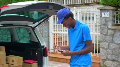 African delivery man doing inventory next to a van Stock Footage 284420964