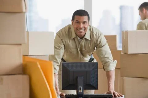 African delivery man next to computer Stockfoto's