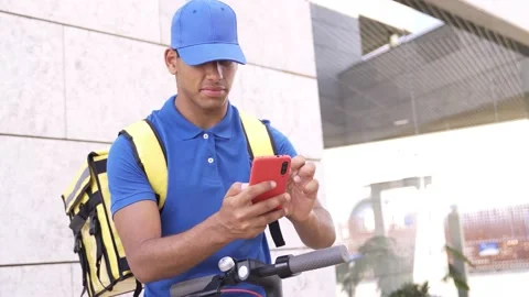 African delivery man using gps smartphone app for food order riding scooter Stock Footage 158708896