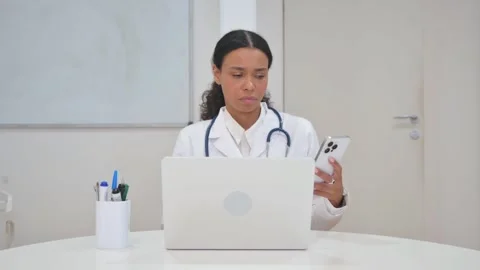 African Doctor Using Smartphone and Laptop Video stock 310065477