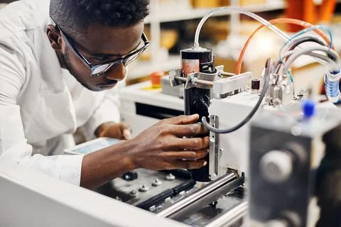 African engineer programming equipment with tablet at factory Stock-Fotos