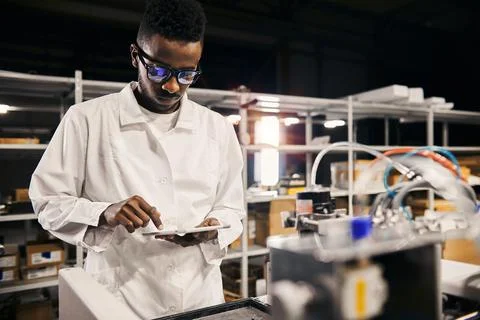 African engineer programming equipment with tablet at factory Stock-Fotos