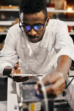 African engineer programming equipment with tablet at factory Stock-Fotos