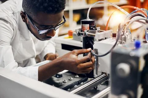 African engineer programming equipment with tablet at factory Stock-Fotos