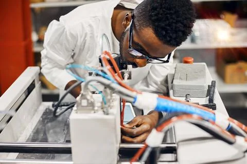 African engineer programming equipment with tablet at factory Stock-Fotos