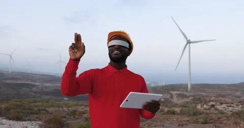 African engineer working at windmill farm using digital tablet Stock Footage 194267325