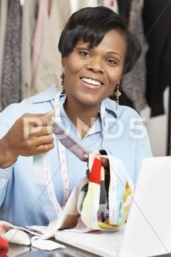 African fashion designer holding fabric swatches Stock-Fotos
