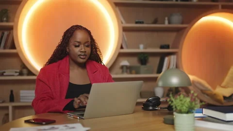 African female accountant working with documents in front of a laptop in office 库存影片 340763192