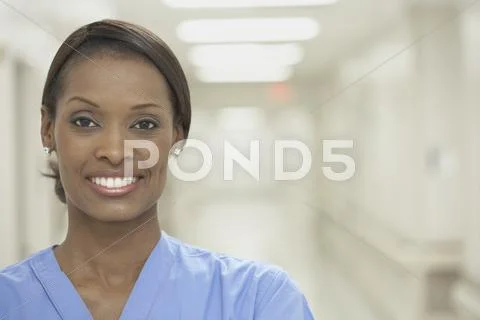 African female nurse smiling in hospital corridor Stock Photos