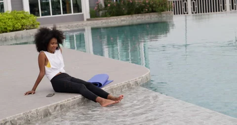 African female sitting at poolside Stock Footage 195282204