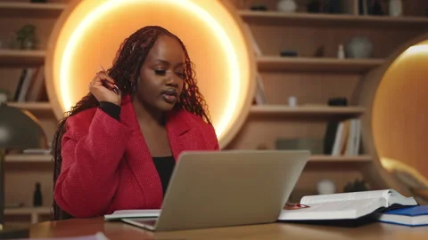 African female student having an online video lesson on laptop and taking notes Stockbeeldmateriaal 340763545