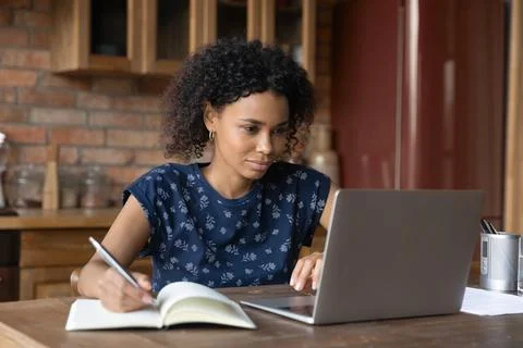 African female study by laptop take notes of internet lecture Stock Photos