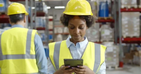 African female worker checking orders for delivery using digital tablet in Stock Footage 151394546