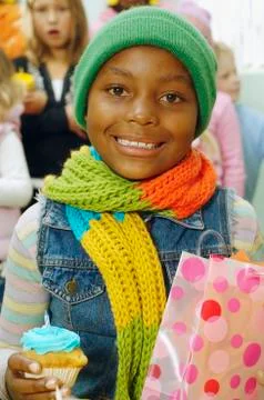 African girl holding cupcake and gift bag Stock Photos