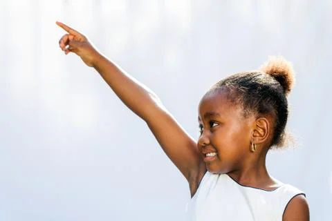 African girl pointing and looking at corner. Stock Photos