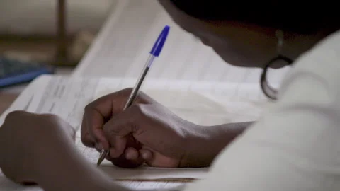 African Girl Writes In A School Notebook. School In An African Village. Stock Footage 257539497