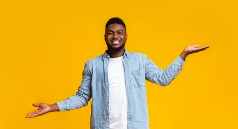 African guy comparing variants, making scales with his empty hands Stock Photos