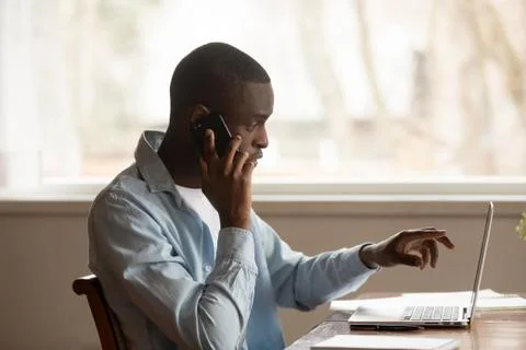 African guy looking at computer screen talk on phone Stock Photos
