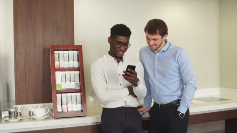 African guy with phone talking with his friend during the break Stock Footage 101717944