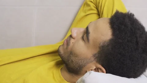 African guy is tired lying on the couch Stock Footage 179965850