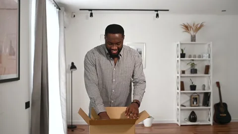 An African guy is unpacking a parcel box Stockbeeldmateriaal 153101579