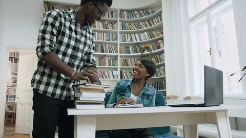 African guy walking to the library, giving five to attractive african girl and Stock Footage 101890823