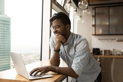 African guy working on computer smiling lead pleasant remote chat 스톡 사진