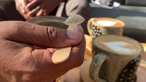 African hand adding sugar to a full cup of coffee Stock Footage 260588220