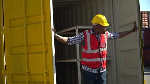 African harbor worker checking list quality walking out of inside Container.. Stock Footage 242309216