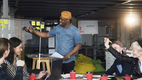 African hipster man presenting result of new business plan to the cowoker during Stock Footage 108398165