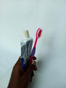 African holding empty Pepsodent toothpaste tube and old toothbrush. Stock Photos