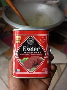 African holding tin of Exeter corned beef Stock Photos