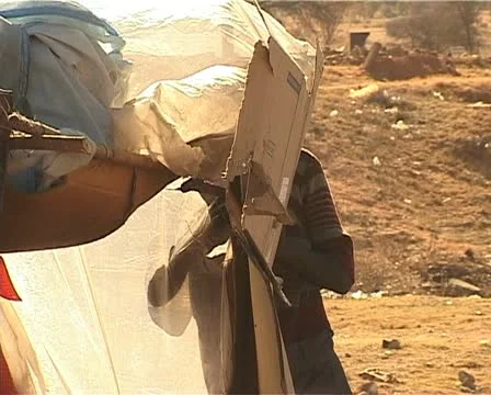 African kid making his shack at a dumpsite Stock Footage 11496882
