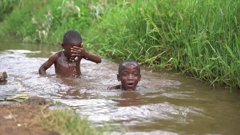 African kids swimming in dirty water Stock Footage