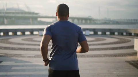 African lone runner doing break in cardio exercise on urban embankment. Stock Footage 103663208